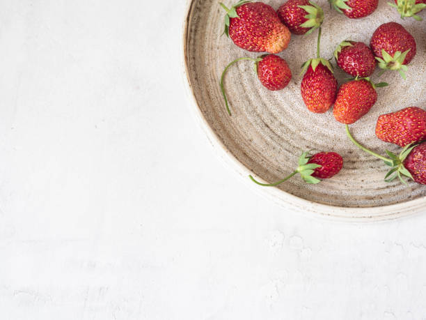 istock Ripe freshly picked red strawberries in a vintage plate on a white background. Top view. Copy space 1252445657