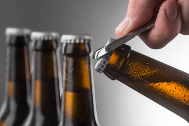 istock Man opening bottle of beer. Selective focus on tilted bottle 1252451860