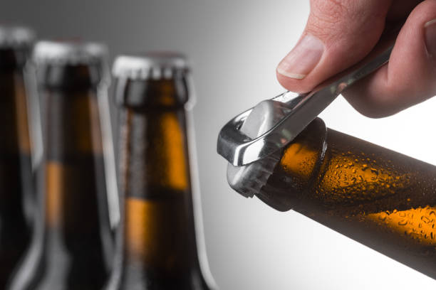 istock Opening cold bottle of beer using a metal opener 1252451884