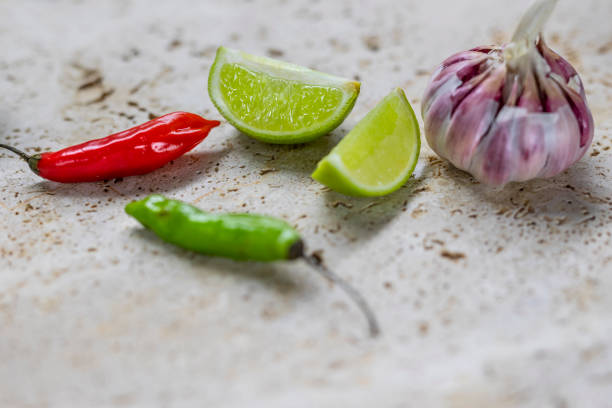 Citrus fruit lime, chili and Capsicum annuum is a species of the plant genus Capsicum (chillies or peppers and capsicums or bell peppers) native to southern North America and northern South America. Garlic ( Allium sativum )