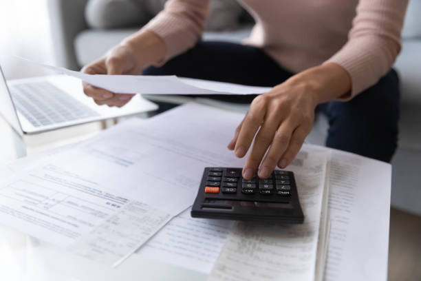 istock Close up woman using calculator, checking domestic bills 1252459201