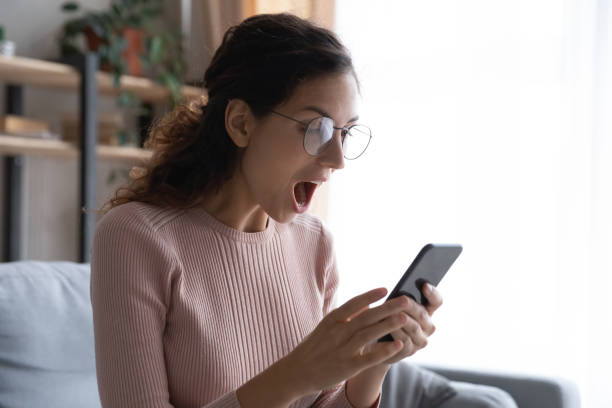 istock Overjoyed woman with open mouth looking at smartphone screen 1252459220