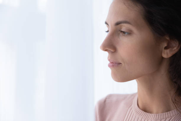 istock Close up thoughtful young woman looking through window 1252459267
