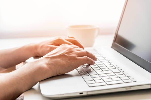 istock Hands of a woman using a laptop while working from home 1252460564