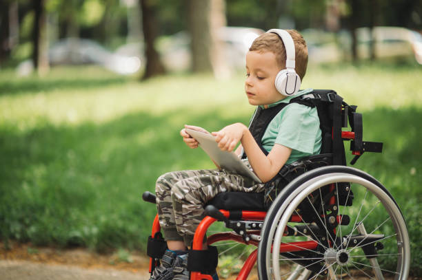Disabled young boy using digital tablet stock photo