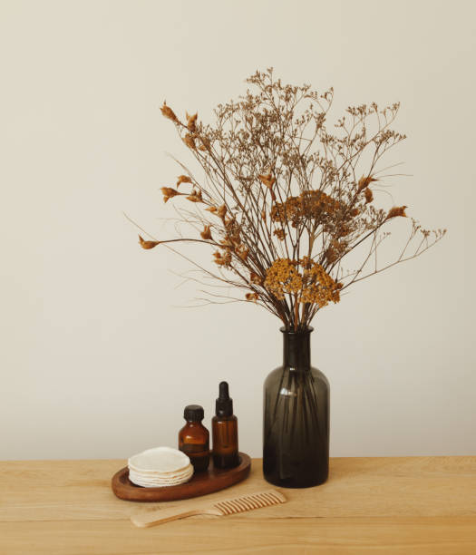 Set of beauty products and toiletries and vase with flowers Set of beauty products and toiletries (serum, essential oil, reusable cotton pads and hair comb) and vase with flowers massage oil photos stock pictures, royalty-free photos & images