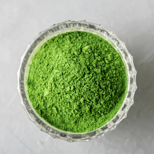 istock Shredded chlorella or spirulina in a glass cup on grey concrete. Top view. 1252477162