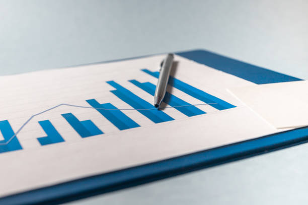 istock growing chart diagram graph in blue colors on annual report with silver pen on blue table, good business growth. Data analyzing concept 1252480781