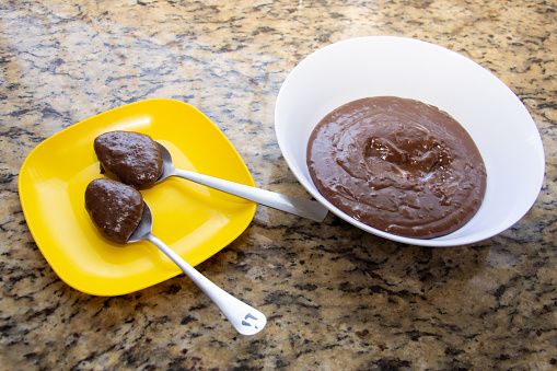 two spoons with brigadeiro on the counter