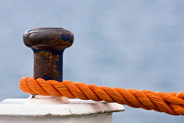 Photo of Rusty bollard with knotted mooring rope