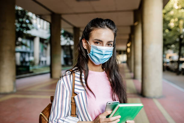 istock Young female student wearing protective face mask during pandemic 1252483329