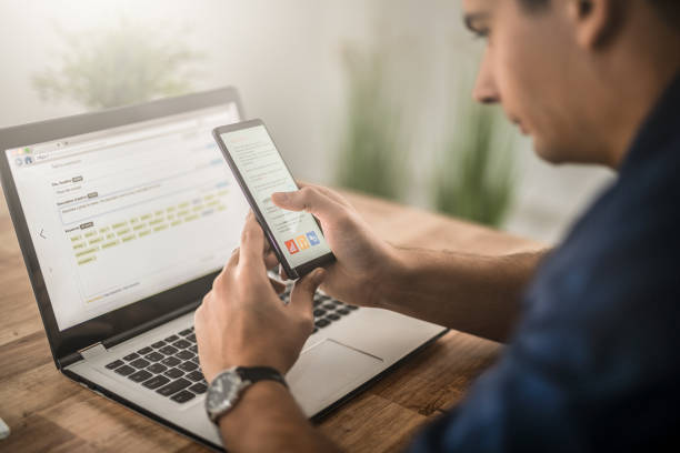 istock Man works at home and uses a smart phone and notebook computer. 1252484337