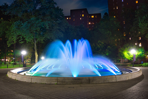 Blue, round colored water fountain at night