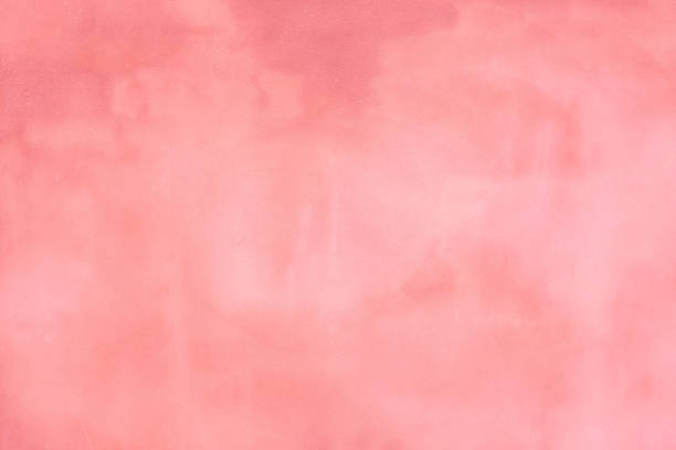 istock Rustic pink blush concrete cement wall with darker and lighter areas to use as a background or banner 1252491396