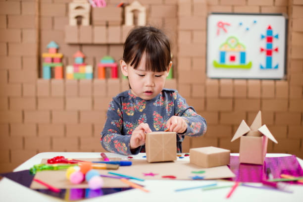 istock Preschooler making craft using cardboard blocks at home 1252493927