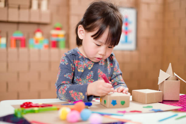 istock Preschooler making craft using cardboard blocks at home 1252493957