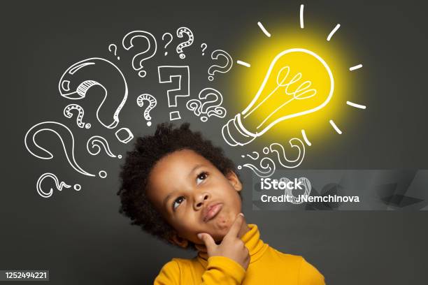 Thinking Child Boy On Black Background With Light Bulb And Question Marks Brainstorming And Idea Concept Stock Photo - Download Image Now