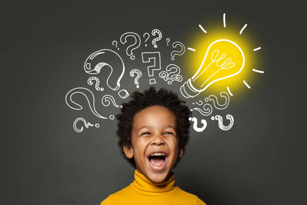 istock Laughing child boy student with lightbulb and question marks. Brainstorming and idea concept 1252494236