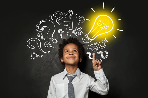 istock Clever little boy on black background with light bulb. Brainstorming and idea concept 1252494238