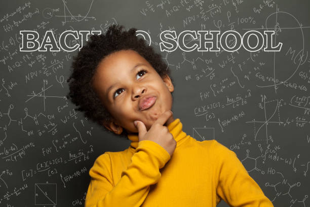istock Child against chalkboard background. Back to school concept 1252494245