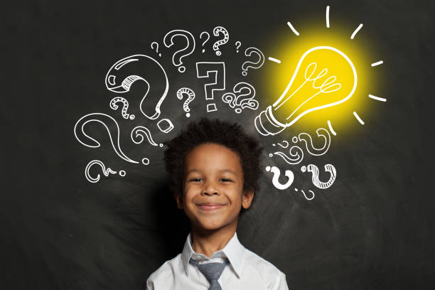 istock Idea concept. Black boy student with lightbulb on blackboard background 1252494247