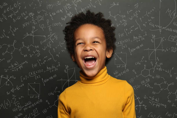istock Happy child boy on chalkboard background with science formulas 1252494248