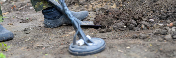 istock coil electronic metal detector device for search a treasure and the a man's foot is digging with a shovel. banner 1252496536