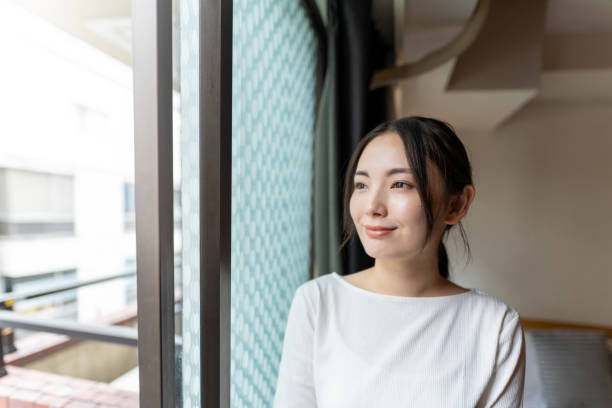 Asian woman standing by the window