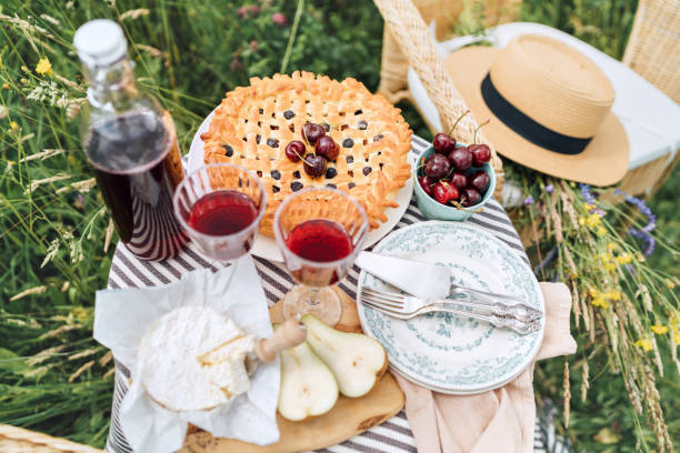 istock Table top view served with beautiful vintage wine glasses, silver cutlery, plates and tableware, tablecloth, sweet cherry pie and fresh cherries still life. Homemade baking and recipes illustration. 1252498229
