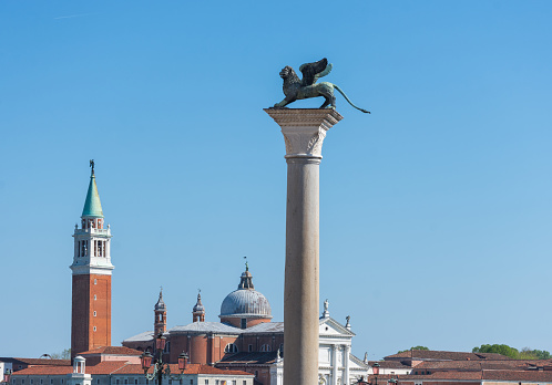The St. Mark's Square (Piazza San Marco) with column with winged lion and San Giorgio di Maggiore church in the background, in Venice, Italy