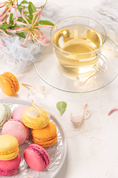 istock Colorful french macaroon cakes. Macaroons with jasmine flowers on white table background. Selective focus 1252500657