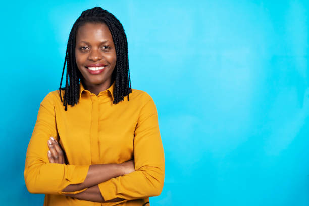 Studio portrait of an African-American woman posing against blue background Studio portrait of an African-American woman posing against blue background. formal portrait photos stock pictures, royalty-free photos & images