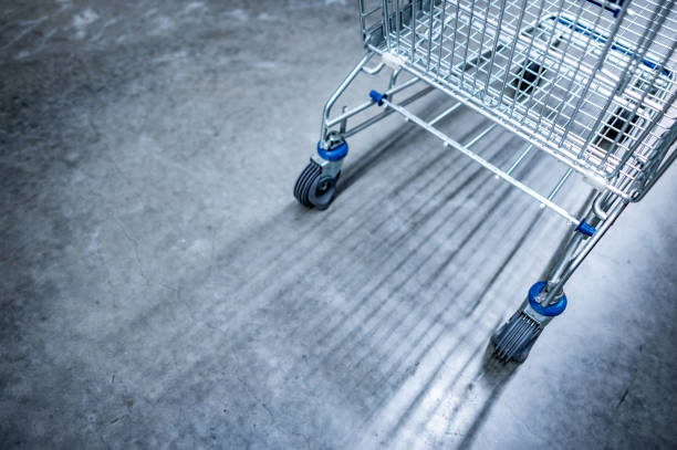 Empty shopping cart or shopping trolley in on concrete floor in supermarket or grocery store. Buying concept