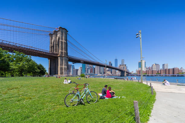 Brooklyn, New York, USA - June 13, 2020:  view of the Brooklyn bridge and Manhattan from Empire Fulton Ferry park during covid-19 pandemic . New Yorkers practicing social distancing.