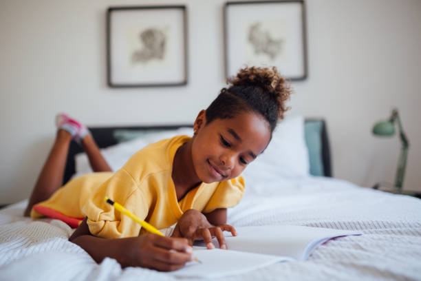 little african american girl doing homework - child thinking writing little girls imagens e fotografias de stock