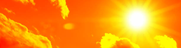 istock Bright sun with beautiful beams in the sky with clouds (toned in red) 1252507267