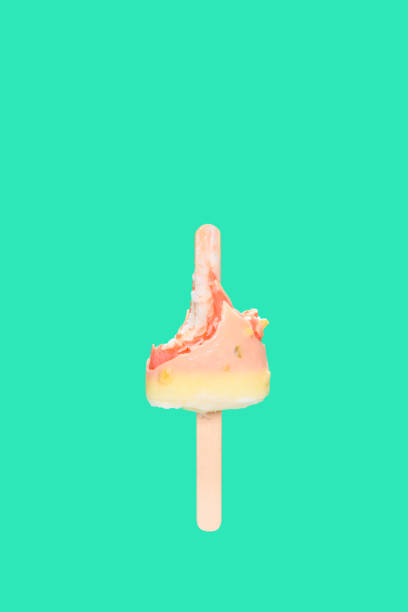 istock mostly eaten white chocolate outer popsicle with red inner on green background 1252520052
