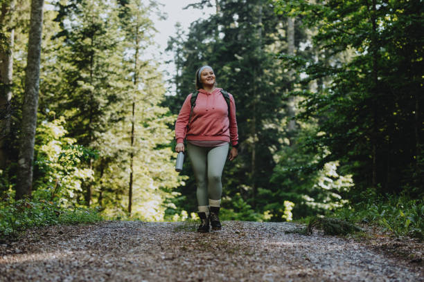 istock Smiling Plus Size Woman With a Backpack Walking in Nature Alone 1252521204