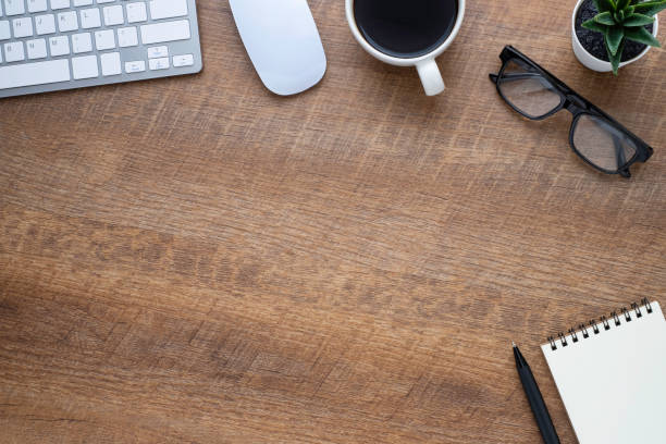 istock Wood office desk table with keyboard, notebook and coffee cup with equipment other office supplies. Business and finance concept. Flat lay with blank copy space. 1252528545