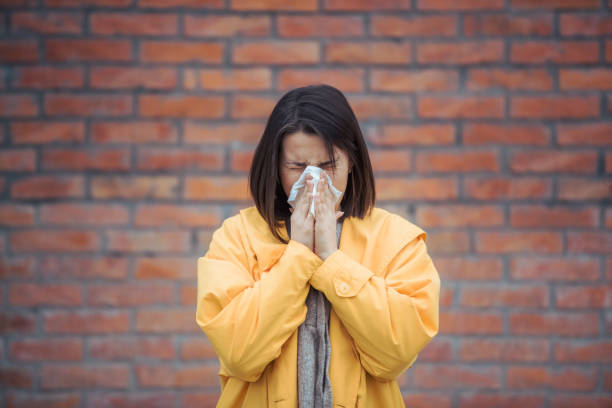 istock Sick young woman blowing her nose 1252538115