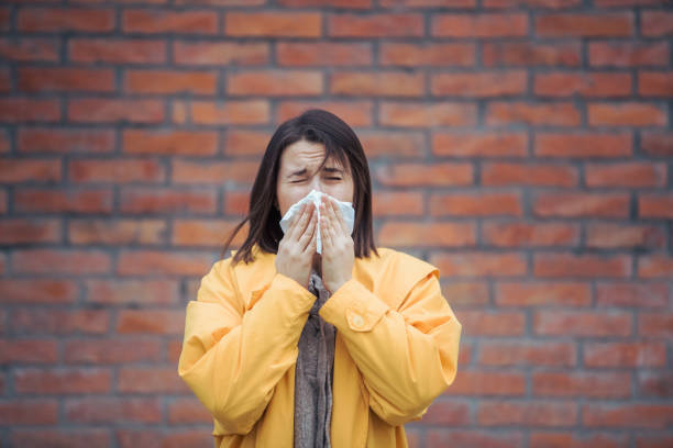 istock Sick young woman blowing her nose 1252538117
