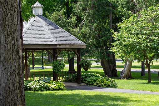 View of a landscaped wooden gazebo in a city park