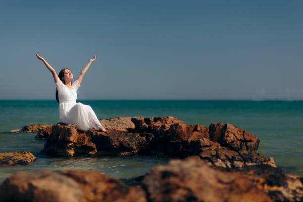 happy woman with raised arms by the sea - bride wedding freedom arms raised imagens e fotografias de stock