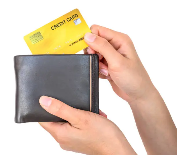 Photo of Someones hand holding leather wallet with credit card isolated on white background.