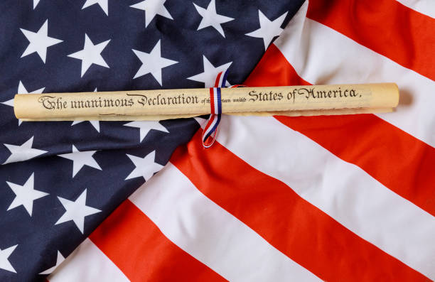 istock The unanimous declaration document. Fourth of July Day. Declaration of Independence parchment roll with US flag. 1252566597