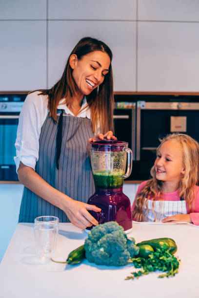 istock Mother and daughter making smoothie 1252568109