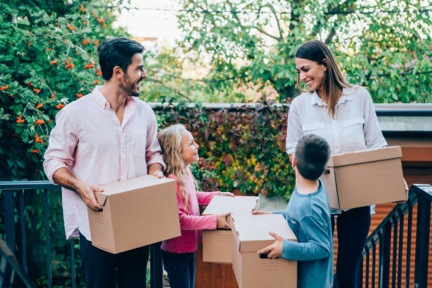 istock Smiling family carrying boxes into their new house. 1252568111