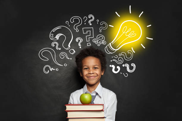 istock Child and Idea concept. Smart boy student with lightbulb and question marks 1252576865