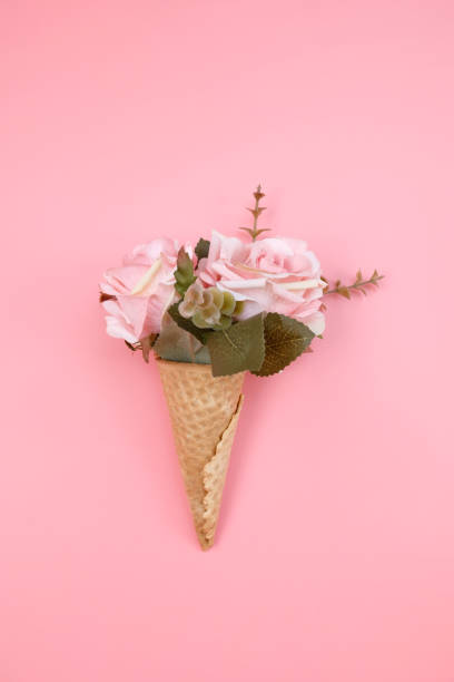 istock Waffle cone with flowers on pink background. Decorations for birthday, anniversary, wedding. Minimal decorative holiday concept. 1252580547