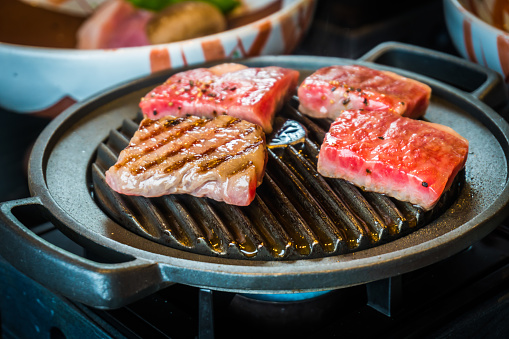 A5 grade Wagyu beef grilled on a hot pan in a Japanese style. Soft Focus
